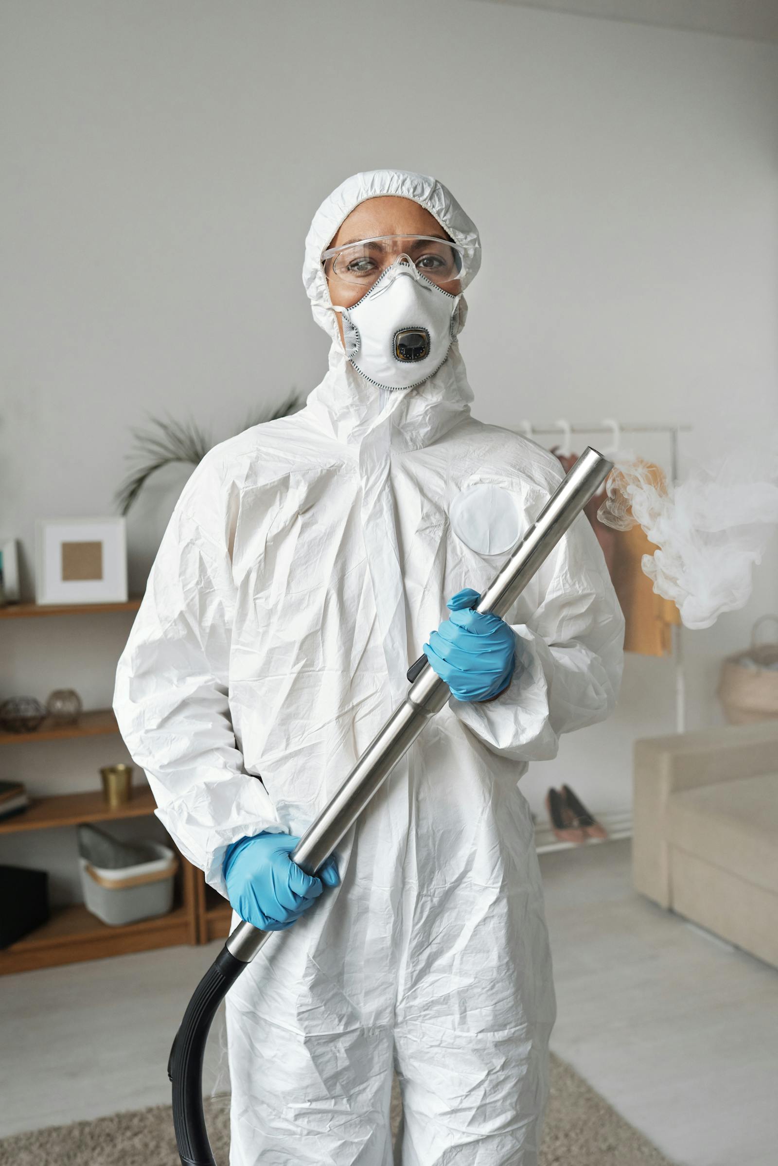 Protective-suit worker disinfecting a kitchen area